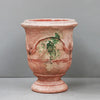 Image of Terracotta urn with decorative elements on a gray background