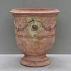 Image of Terracotta urn with decorative patterns on a gray background