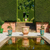Image of Garden scene with decorative urns, steps, and hedges.