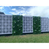 Image of Artificial White Tropics Vertical Garden Wall Panel installed on either side of a patterned white geometric screen