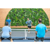 Image of Evergreen Rainforest Recycled Artificial Green Wall Panel framed by wood toned wall paneling with four men actively playing a doubles match of pickleball