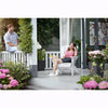 Image of Two people sitting on a porch with flowers and plants around