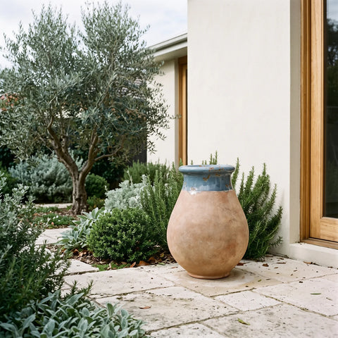 blue glazed French Biot jar with antiqued terracotta base on paved entryway