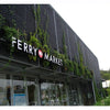 Image of black facade panels installed above a market entrance with plants growing on it