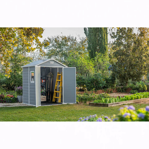 Gray garden shed with a yellow ladder in a garden setting
