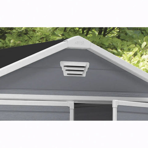 Roof with a vent and gray covering, greenery in the background