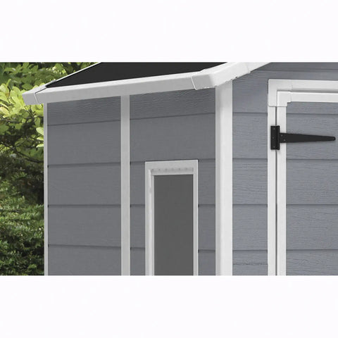 Gray storage shed with a white door and black handle, surrounded by greenery.