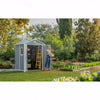 Image of Person standing outside a garden shed in a garden setting with trees and plants.