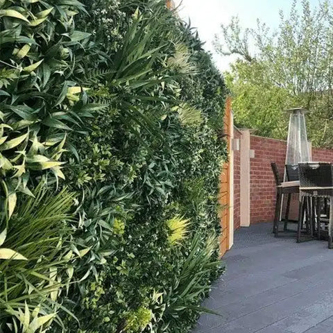Artificial Green Forest Vertical Garden Panel Installed Outdoors on brick wall in a patio area with seating