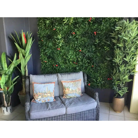 Artificial Red Tropics Vertical Garden Panel Installed on patio with small outdoor couch in the foreground