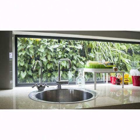 Modern kitchen sink with a view of greenery wall outside