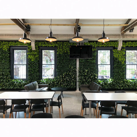 Modern office space with green wall, tables, and chairs.