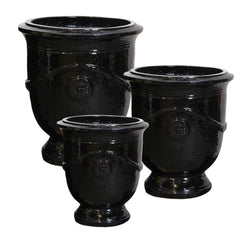 Set of three black ceramic urn-shaped planters on a white background