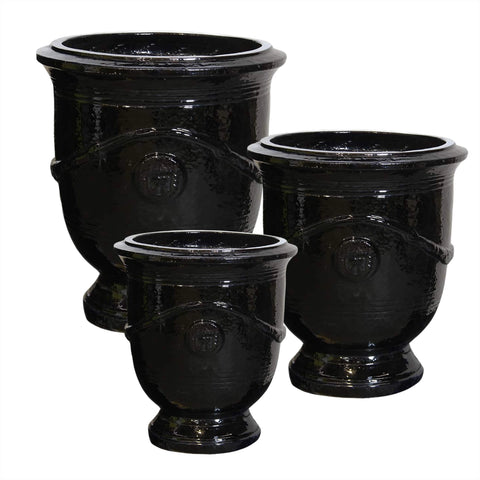 Set of three black ceramic urn-shaped planters on a white background