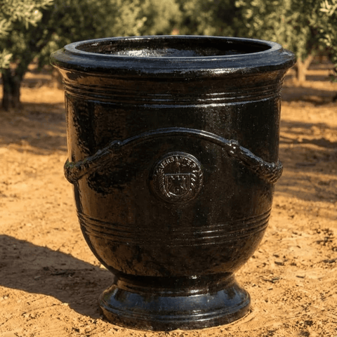 black glazed french anduze urn outdoors on gravel