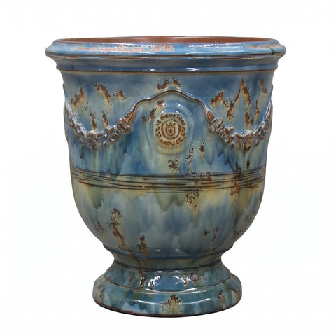 Decorative ceramic planter with blue glaze and rustic design on a white background