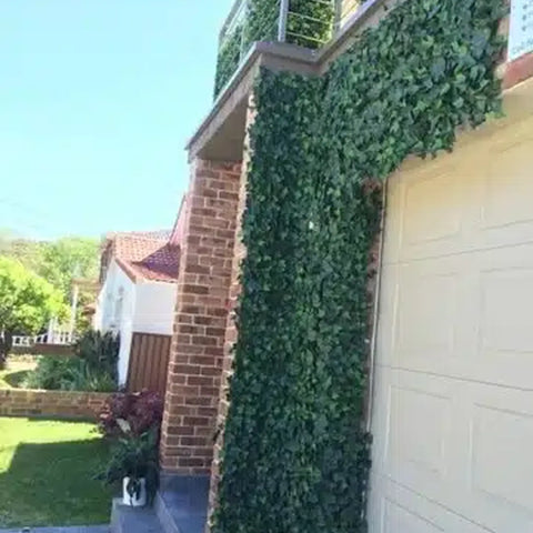 Artificial Ivy Leaf Hedge Panel installed around the corner of the parking gate next to the main door