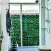 Image of A bathroom with a walk in shower with a large glass wall that looks out onto a mounted Artificial Ivy Leaf Hedge 1m x 1m Plant Wall Screening Panel UV Protected outdoors