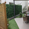 Image of Modern patio with a wooden privacy screen and Artificial Ivy Leaf Hedge Panels featuring a tiled seating area and a strip of vibrant artificial grass