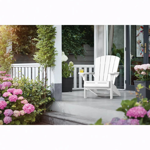 White Adirondack chair on a porch with flowers and plants around